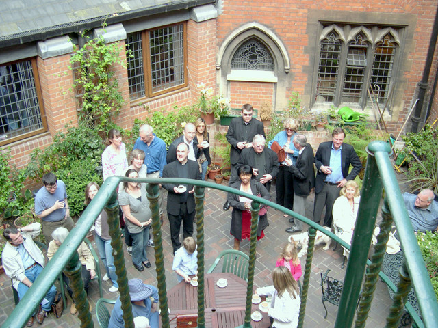 Vicar Philip, of St. Matthew Church, left of center, thanks us for our music as the congregation gathers in the courtyard for refreshments.
